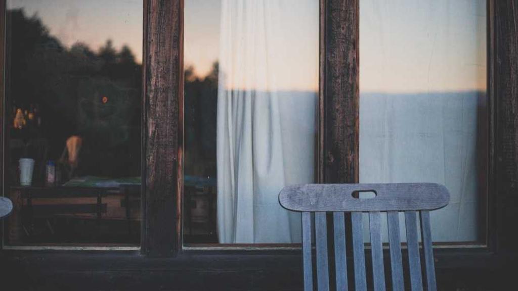 学生看着手机里‘稳赚不赔’的诈骗信息，身后墙上挂着反诈宣传海报